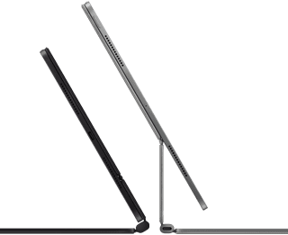 Dva iPady Pro připnuté k Magic Keyboardu, pohled z boku, tenký profil, vesmírně černá barva, reproduktory a USB‑C port, jeden napůl otevřený, druhý ve stříbrné barvě otevřený a nakloněný dozadu, takže je vidět plovoucí konzolová konstrukce klávesnice, reproduktory a mikrofon