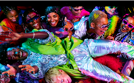 MacBook Pro with a colourful image of a person crowd-surfing at a party to showcase the rich colours of the Liquid Retina XDR display
